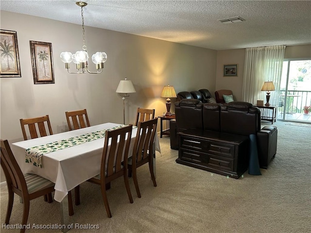 dining room with light carpet, a textured ceiling, and visible vents