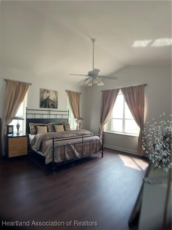 bedroom featuring lofted ceiling, a ceiling fan, and wood finished floors