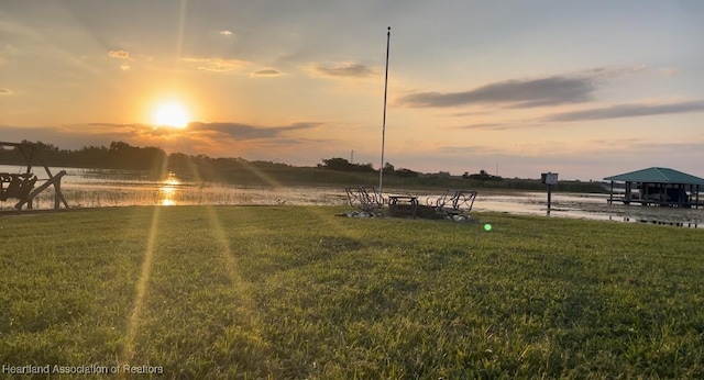 yard at dusk featuring a water view