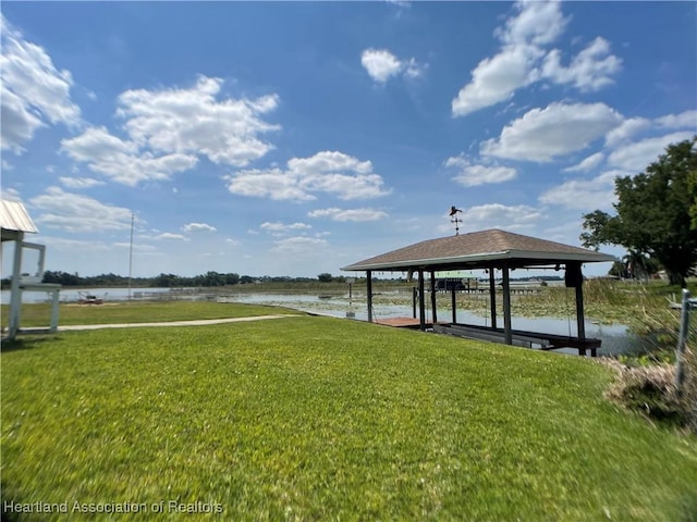 dock area with a yard and a water view