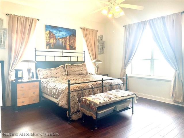 bedroom with a ceiling fan, baseboards, and hardwood / wood-style flooring