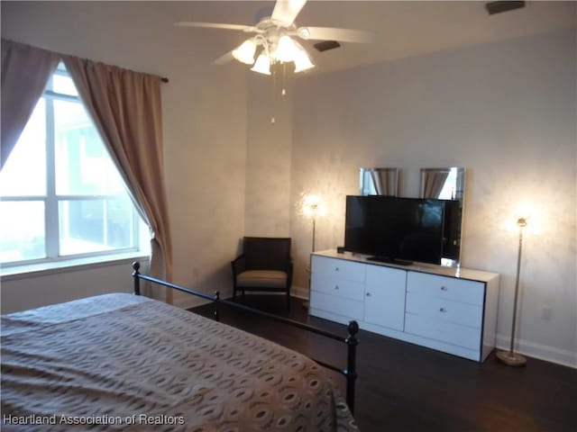 bedroom featuring baseboards, dark wood-style flooring, and multiple windows