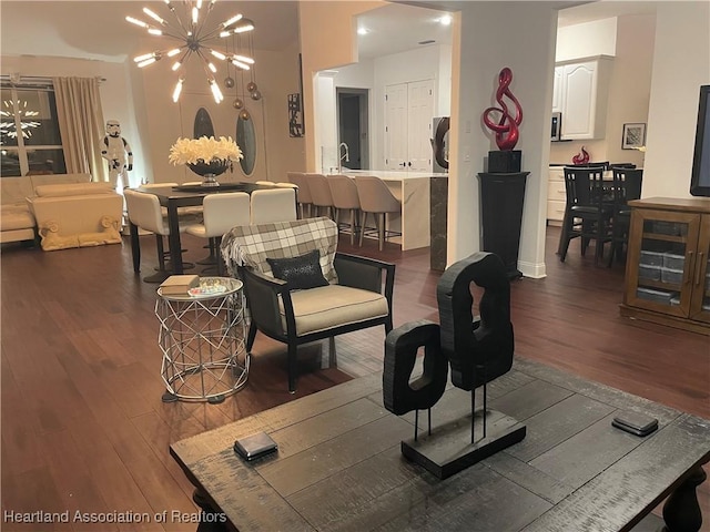 living room with a notable chandelier and dark wood-style flooring