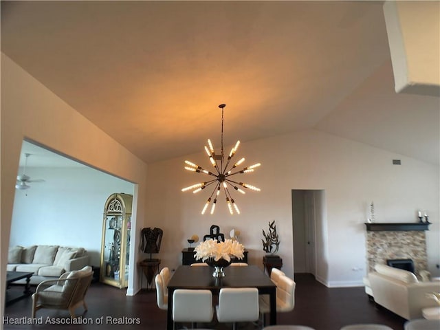 living area with a fireplace, lofted ceiling, and ceiling fan with notable chandelier