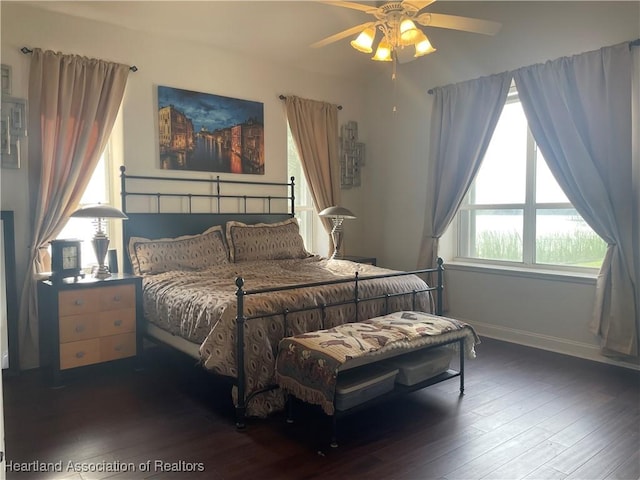 bedroom with a ceiling fan, baseboards, and wood finished floors