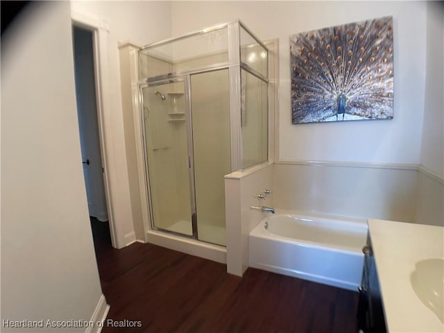 bathroom featuring a garden tub, vanity, wood finished floors, and a stall shower