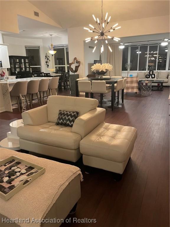 131 Temptation Ct, Lake Placid, FL 33852 - living room with lofted ceiling, dark wood-style floors, and a chandelier