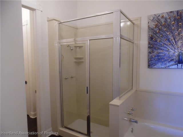 full bath with a bath and a shower stall