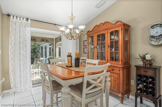 dining room featuring light tile patterned floors, a chandelier, and lofted ceiling