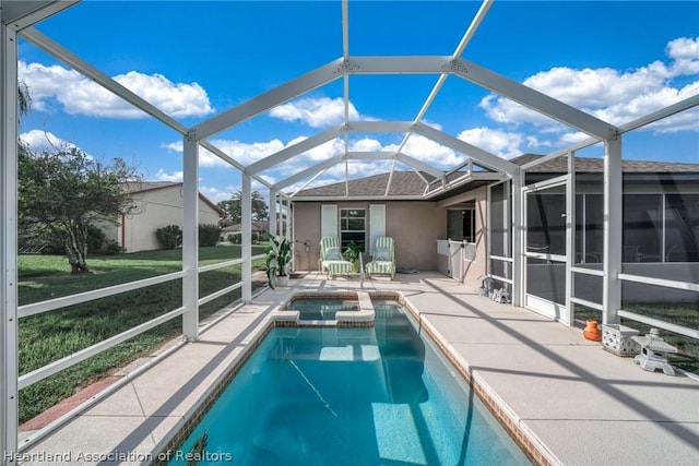 view of pool featuring a lawn, glass enclosure, an in ground hot tub, and a patio