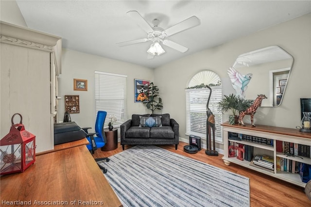 living area featuring light hardwood / wood-style flooring and ceiling fan