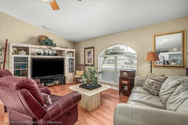 living room with light hardwood / wood-style floors, ceiling fan, and lofted ceiling