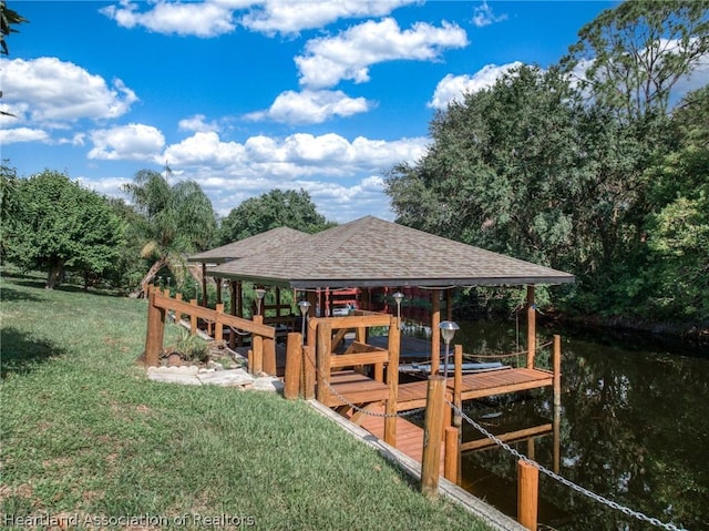 view of dock with a water view and a yard