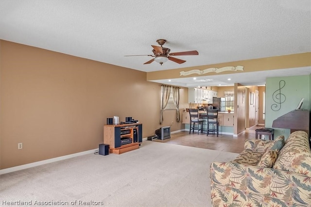 living room with carpet, a textured ceiling, and ceiling fan