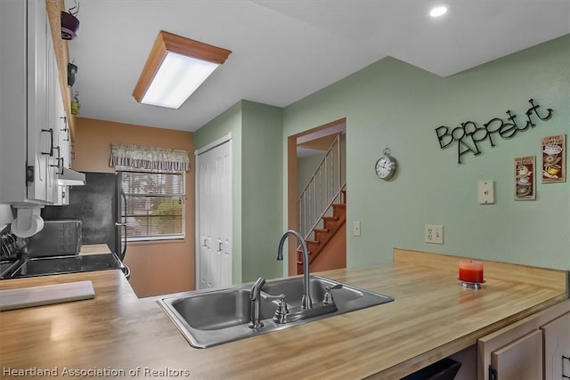 kitchen featuring exhaust hood, stove, and sink