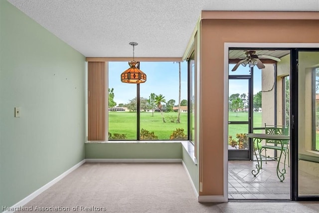 doorway featuring ceiling fan, plenty of natural light, and carpet floors