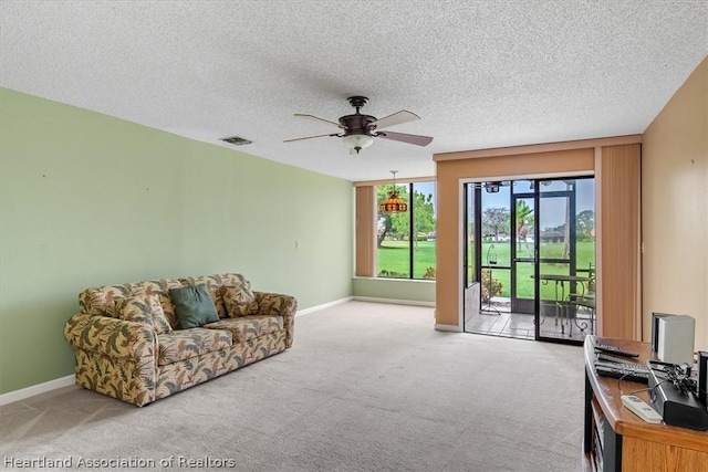 living room with carpet, ceiling fan, and a textured ceiling