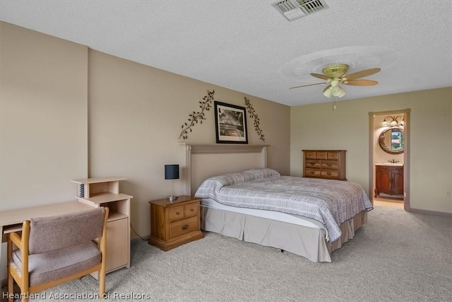 bedroom featuring connected bathroom, ceiling fan, light carpet, and a textured ceiling