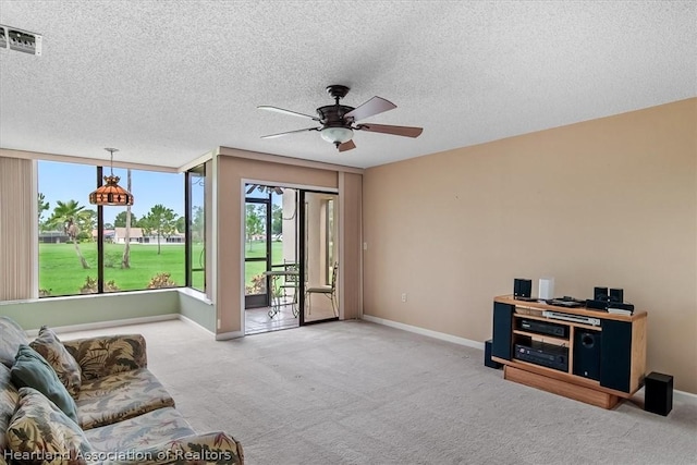 living area featuring carpet, a textured ceiling, and ceiling fan