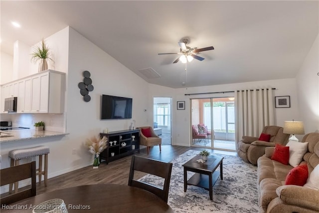 living room with ceiling fan, vaulted ceiling, and dark hardwood / wood-style floors