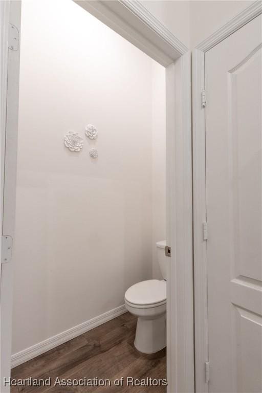 bathroom with toilet and wood-type flooring