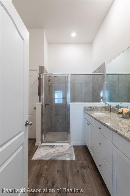 bathroom with hardwood / wood-style flooring, an enclosed shower, and vanity