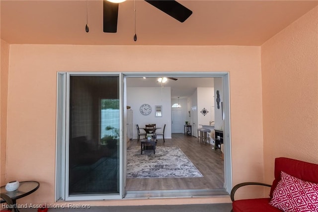 entrance to property with ceiling fan and a patio area