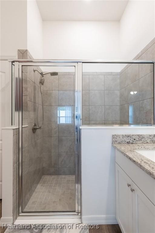 bathroom with vanity and a shower with shower door