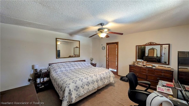 carpeted bedroom featuring ceiling fan and a textured ceiling