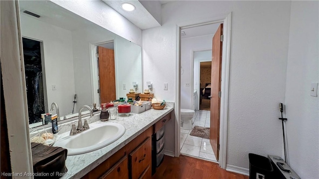 bathroom with vanity, hardwood / wood-style floors, and toilet