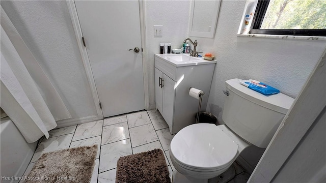 bathroom featuring vanity, walk in shower, and toilet