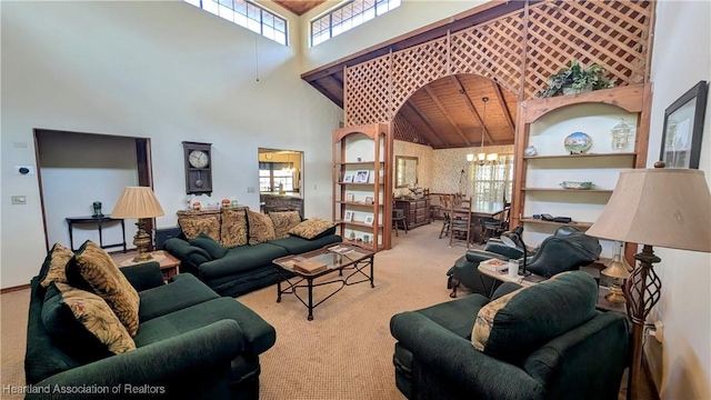 carpeted living room with an inviting chandelier and a towering ceiling