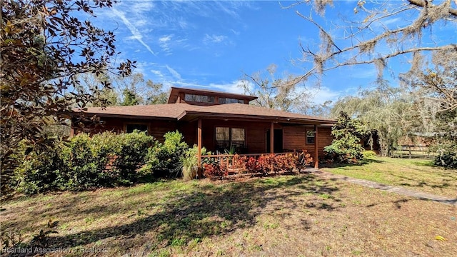 rear view of property featuring a lawn