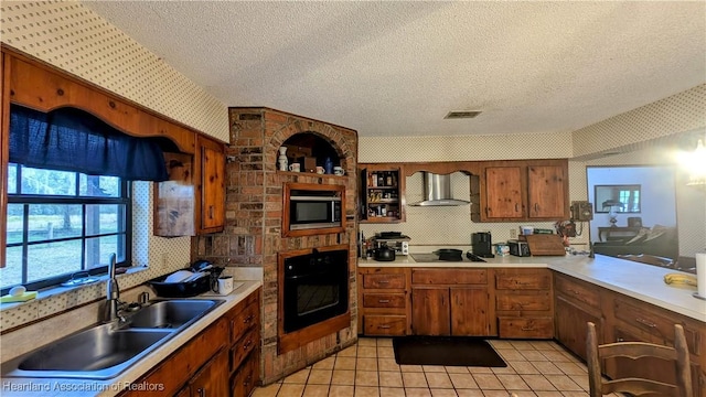 kitchen with wall chimney exhaust hood, sink, a textured ceiling, light tile patterned floors, and black appliances