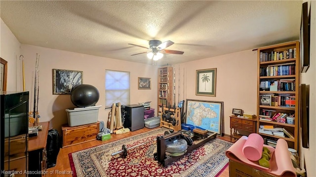 interior space featuring ceiling fan, hardwood / wood-style flooring, and a textured ceiling