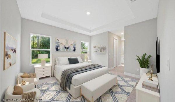 bedroom featuring a raised ceiling and multiple windows