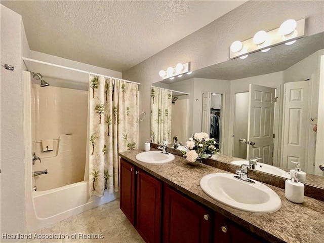 bathroom with a textured ceiling, shower / bath combo with shower curtain, a sink, and double vanity