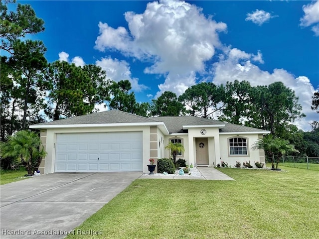 view of front facade with fence, an attached garage, stucco siding, concrete driveway, and a front yard