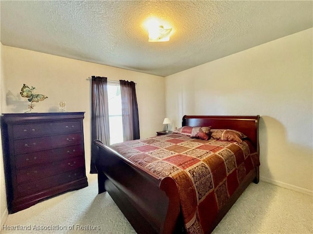 bedroom featuring a textured ceiling, baseboards, and carpet floors