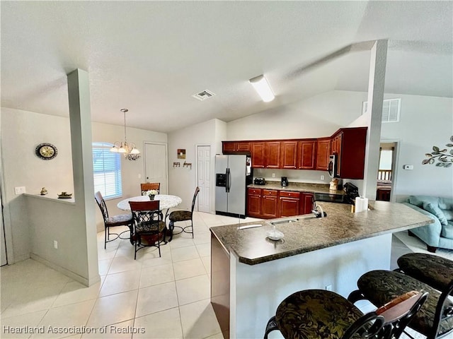 kitchen featuring dark brown cabinets, dark countertops, stainless steel fridge with ice dispenser, visible vents, and lofted ceiling