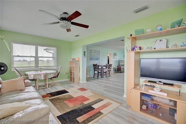 living room with ceiling fan and light wood-type flooring