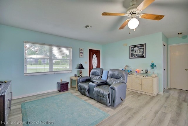 living room featuring ceiling fan and light hardwood / wood-style floors