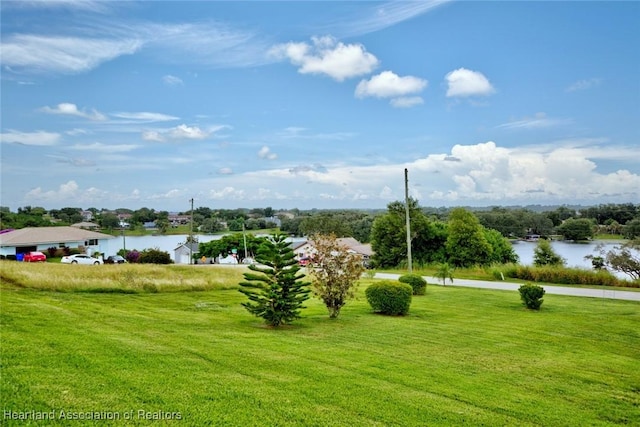 view of property's community featuring a water view and a yard