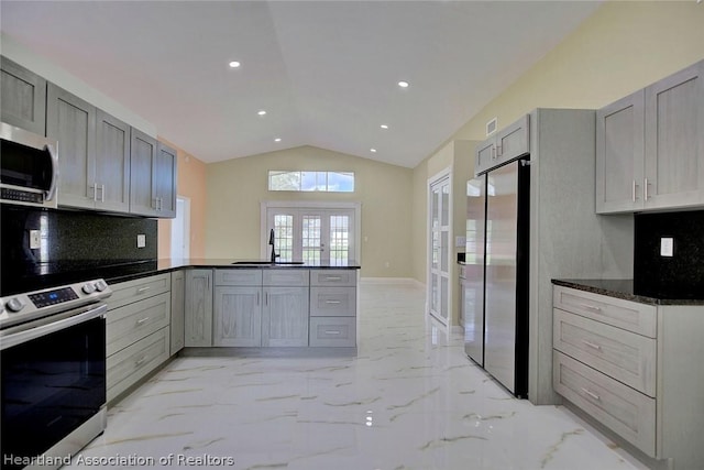 kitchen with kitchen peninsula, appliances with stainless steel finishes, french doors, and gray cabinetry