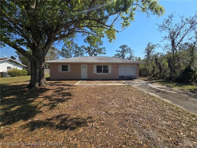 single story home with a garage, driveway, and stucco siding