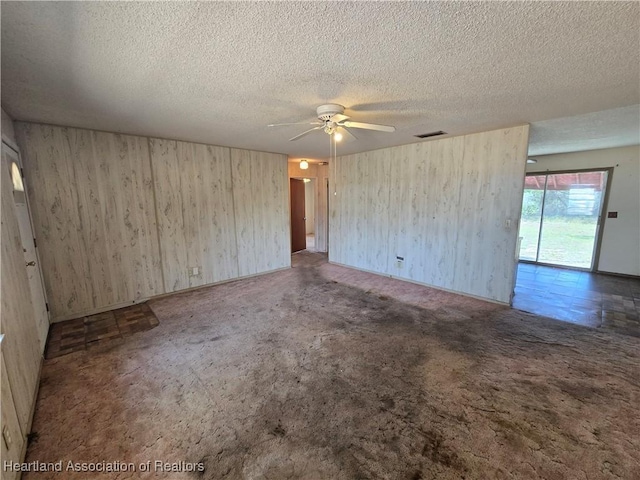 unfurnished room featuring ceiling fan, a textured ceiling, carpet, and visible vents