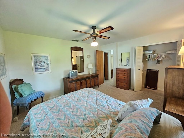 bedroom featuring ceiling fan, a closet, and light colored carpet