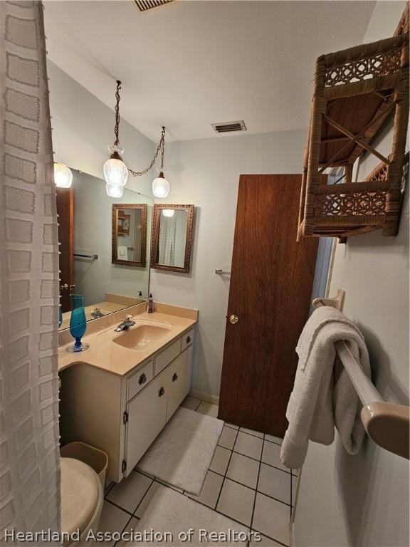 bathroom featuring tile patterned flooring, vanity, and toilet