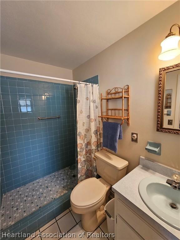 bathroom featuring a shower with curtain, tile patterned flooring, vanity, and toilet