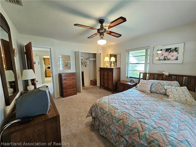 bedroom featuring light colored carpet, a closet, and ceiling fan